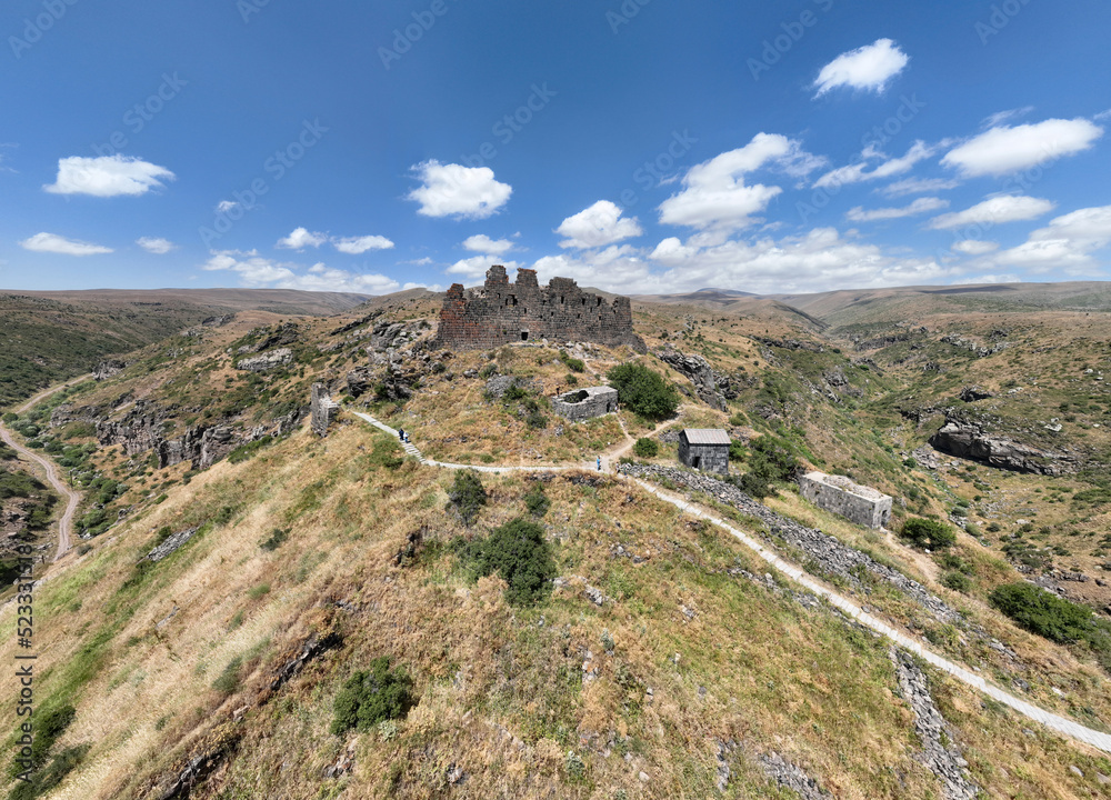 panoramic view of a mountain landscape with an old dilapidated fortress against the sky in Armenia taken from a drone