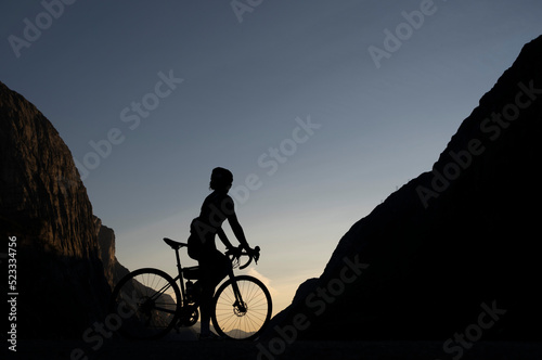 Mujer ciclista a contraluz