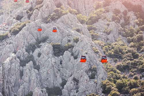 Cable car carries tourists in closed gondolas to a viewing platform high in the mountains. Travel landmarks and transport infrastructure