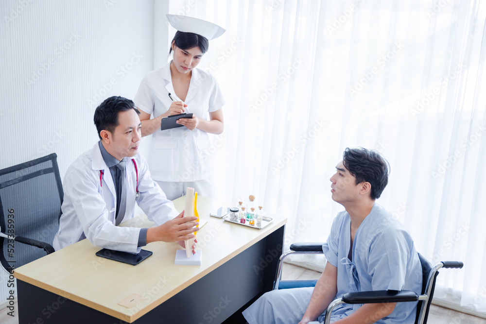 Obraz premium Asian male orthopedic professional doctor and nurse consulting explaining knee bone model to male patient