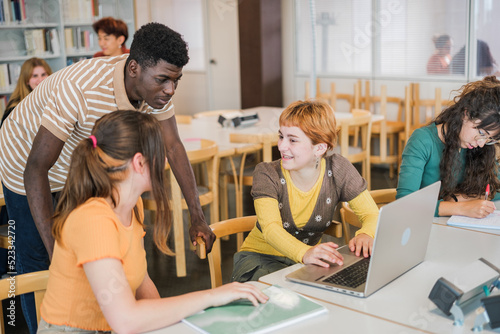 Group of students of different ethnicity in the university library studying together