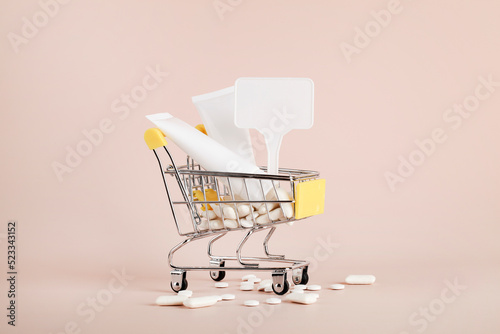 Titanium dioxide, E171, dangerous additive concept. gum, pills, toothpaste, cream in basket and sign with space on beige background. copy space photo