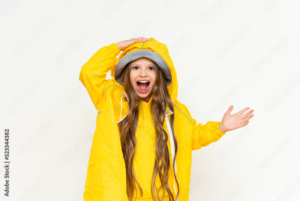 A child in a raincoat on a white isolated background. A little girl with long hair in a yellow raincoat and a panama hat. A child in a raincoat on a white isolated background. A little girl with long hair in a yellow raincoat and a panama hat.