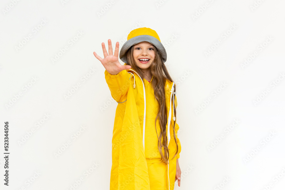 A child in a raincoat on a white isolated background. A little girl with long hair in a yellow raincoat and a panama hat. A child in a raincoat on a white isolated background. A little girl with long hair in a yellow raincoat and a panama hat.