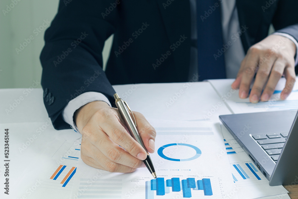Business man analyzing chart and graph showing changes on the market.On the table in the office, the concept of calculating investment results Business man analyzing chart and graph showing changes on the market.On the table in the office, the concept of calculating investment results