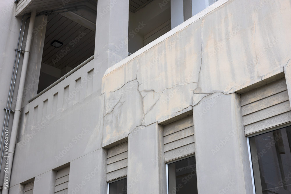 A close-up view of the concrete wall background shows the cracks of an old contemporary building.
