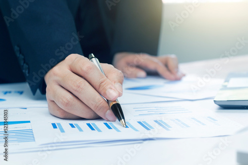 Woman arm holding silver pen point in Marketing financial graph solving. Situation examination at board council sale adviser job stock exchange market profit.