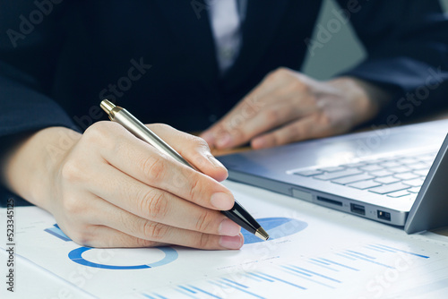Close-up of a business woman analyzing charts and graph showing changes on the market.working in office firm business info.