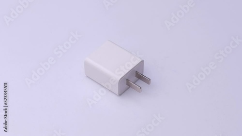 Plug charger for phone up-front on white background, video electronics.