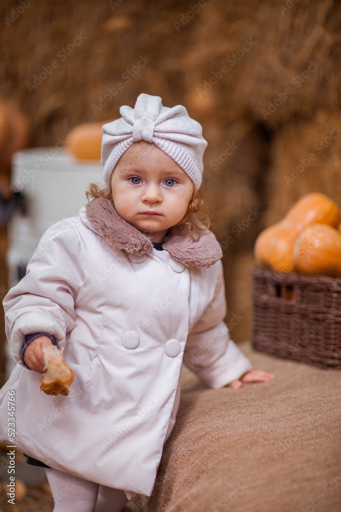 Little girl in beige coat  eating croissant Childhood concept.