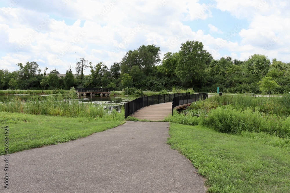 The pathway to the bridge in the park on a sunny day.