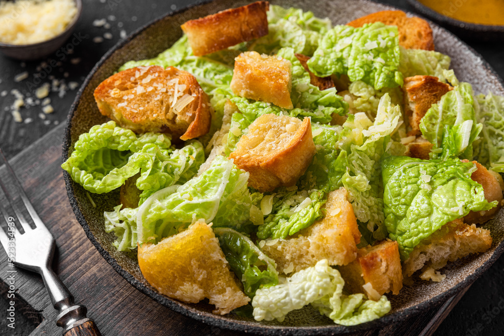 Classic Caesar salad with crisp homemade croutons, parmesan cheese and caesar dressing in a plate