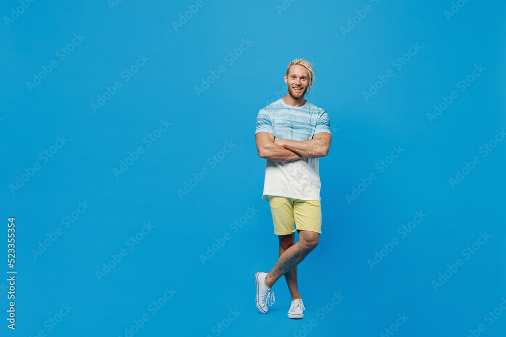 Full body young blond man with dreadlocks 20s he wear white t-shirt look camera hold hands crossed folded look camera isolated on plain pastel light blue background studio. People lifestyle concept. Full body young blond man with dreadlocks 20s he wear white t-shirt look camera hold hands crossed folded look camera isolated on plain pastel light blue background studio. People lifestyle concept.