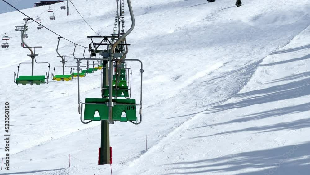 Many ski lift chairs move on rope way at alpine winter resort Many ski lift chairs move on rope way at alpine winter resort