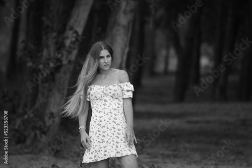 Young woman in dress at the forest in black and white