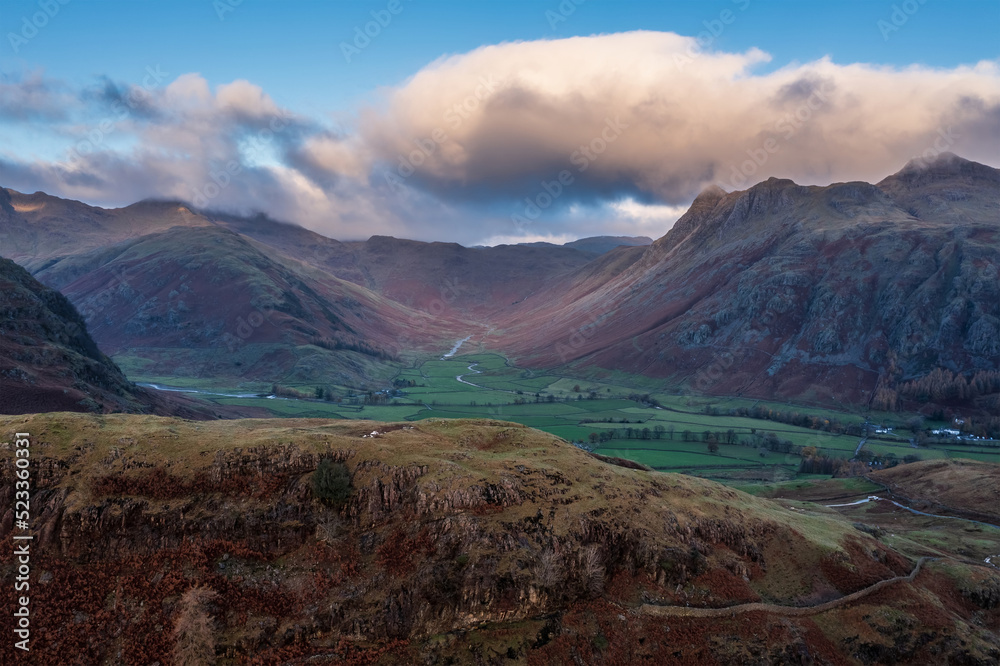 Aerial drone landscape image of sunrise from overlooking the Langdale Pikes in Lake District during stunning Autumn