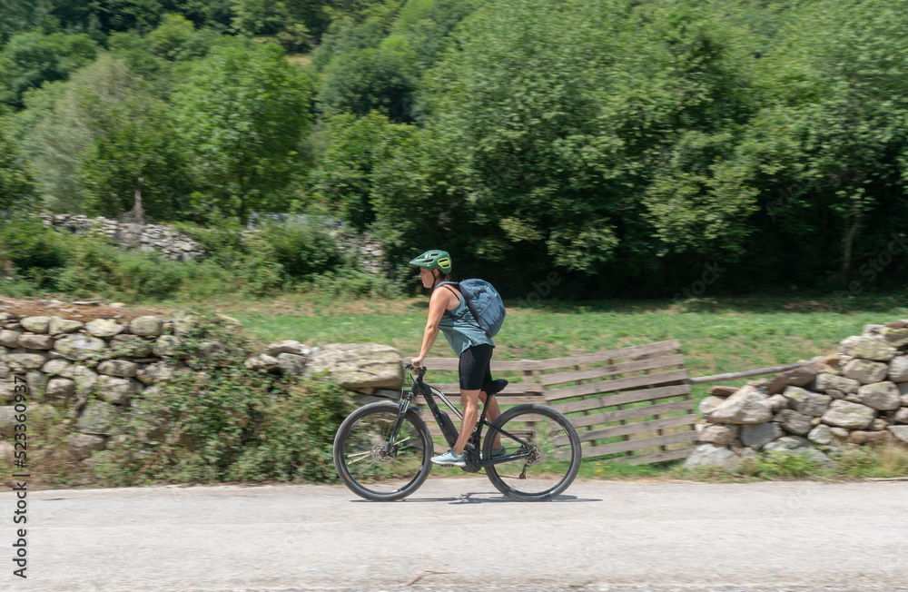 Fototapeta premium woman riding an electric bicycle in the countryside