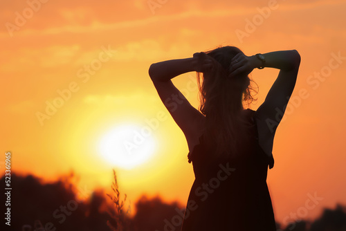 Silhouette of a girl against the backdrop of a sunset.