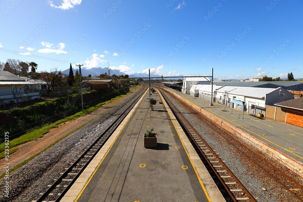 The railway station in Worcester, South Africa, on a clear, sunny day. The tracks are shown leading towards the mountains.