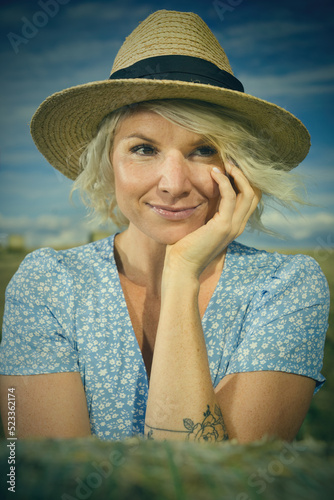 Pretty lady in summer apparel posing on harvested cornfield photo