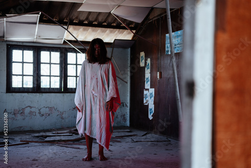 Ghost girl is in an abandoned house dressed in a scary white dress. Bloody lights and red eyes. © 2B