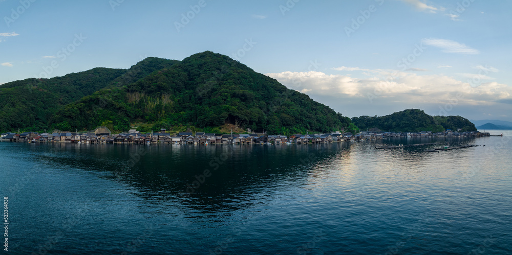 Houses in small fishing village between water and mountain at blue hour