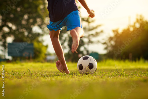 Fototapeta Naklejka Na Ścianę i Meble -  Action sport outdoors of group of kids having fun playing soccer football for exercise in green grass field at community park.