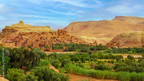 Beautiful central atlas mountains landscape, green oasis, historic maroccan fortified clay village (ksar) on hill,  Ait Ben Haddou, Morocco photo