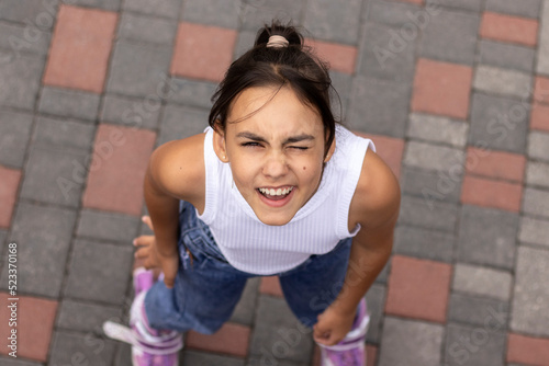 Portrait of a young girl with positive emotions in casual clothing. Top view.