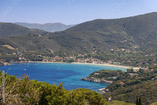 Fototapeta Naklejka Na Ścianę i Meble -  View of gulf and Spiaggia di Procchio, Punta Agnone, village of Procchio and mountains densely overgrown with forest. Province of Livorno,  Island of Elba, Italy