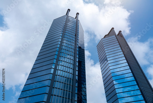 Modern tower buildings or skyscrapers in financial district with cloud on sunny day. bottom view