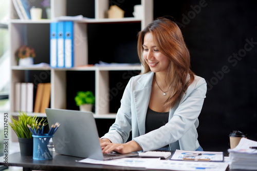Beautiful Asian businesswoman working on laptop computer in the office. © amnaj