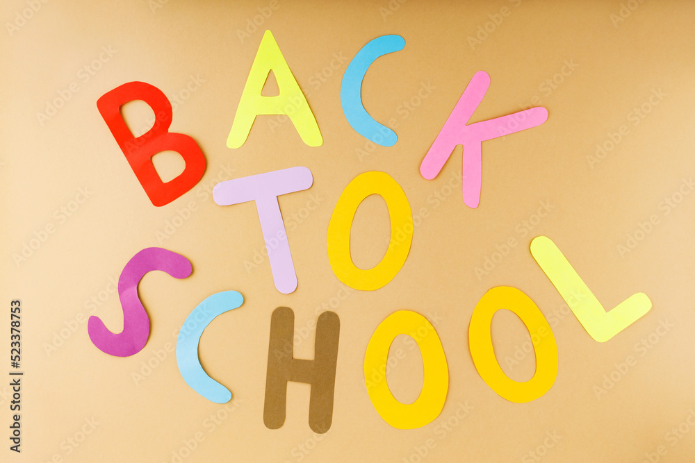 Back to school on a beige background. Inscription Back to school with hand-cut paper letters. Education concept Back to school on a beige background. Inscription Back to school with hand-cut paper letters. Education concept