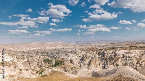 Red Valley and Rose Valley of Goreme of Nevsehir in Cappadocia aerial timelapse, Turkey. Love valley and fairy chimneys panoramic view with clouds on a blue sky photo