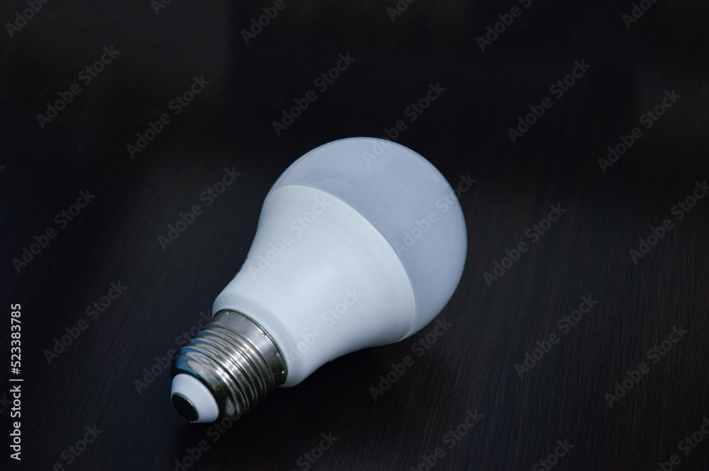 white light bulb empty on black wooden floor white light bulb empty on black wooden floor