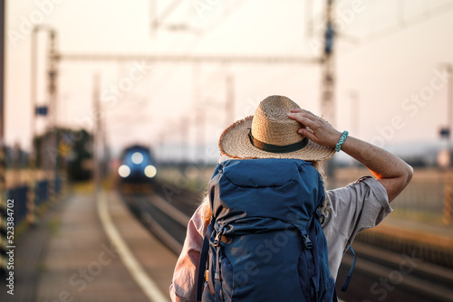 Travel by train. Woman with hat waiting for train at railway station