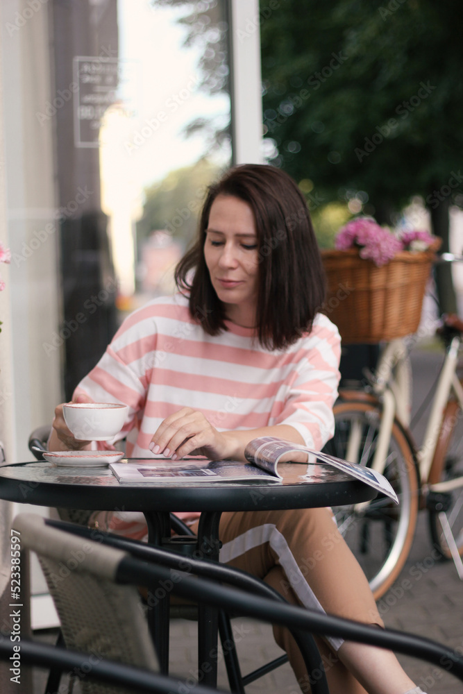 woman in a cafe on a city street woman in a cafe on a city street