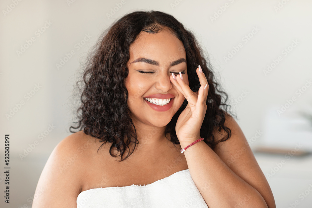 Natural essential beauty. Joyful black plus size lady with closed eyes touching her soft flawless skin, laughing Natural essential beauty. Joyful black plus size lady with closed eyes touching her soft flawless skin, laughing