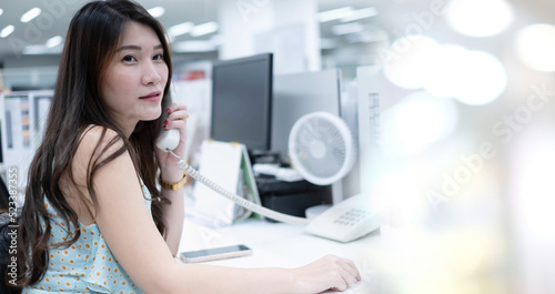 Fototapeta Naklejka Na Ścianę i Meble -  Successful businesswoman in Modern office. Confident woman wearing casual clothes. Portrait of young smiling asian woman. Happy girl in creative office. Happy asian Businesswoman Using Computer.