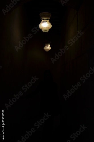 dark alley with two lanterns on the wall with light