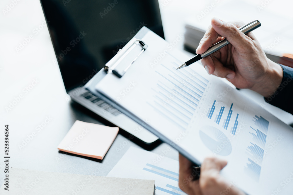 Close up of business hands working and calculating on financial and accounting graft and chart in office space. Close up of business hands working and calculating on financial and accounting graft and chart in office space.