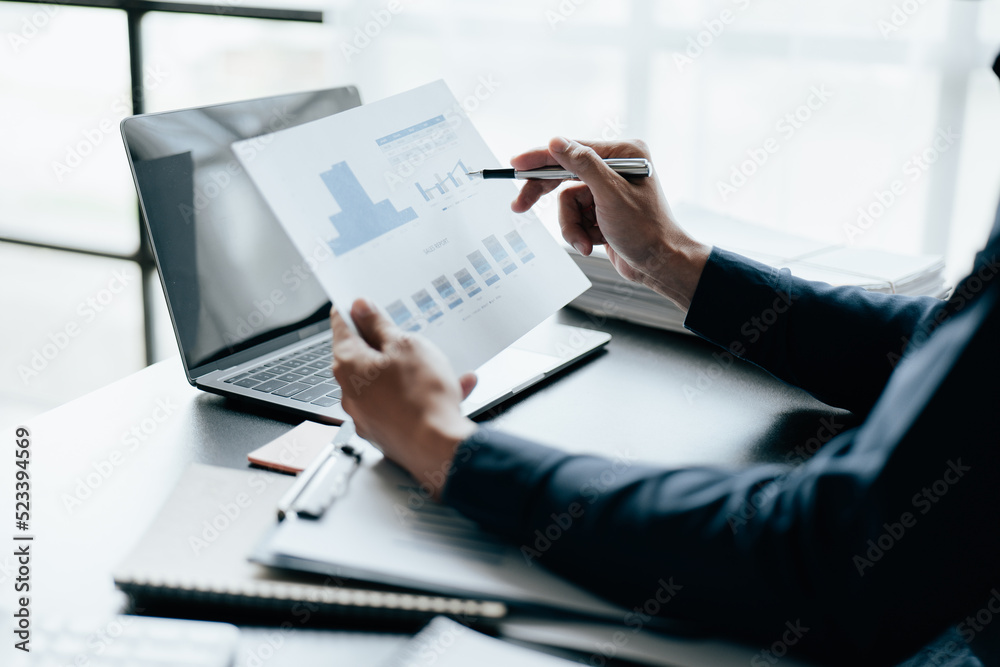 Close up of business hands working and calculating on financial and accounting graft and chart in office space. Close up of business hands working and calculating on financial and accounting graft and chart in office space.