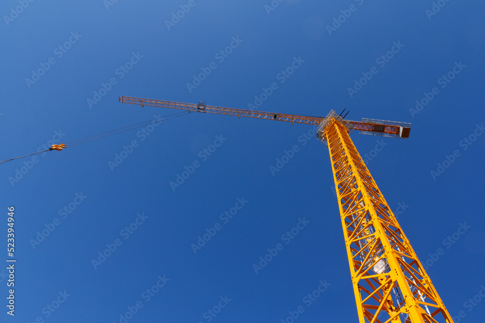 Construction crane on the background of a blue sky. Lifting equipment. Construction Construction crane on the background of a blue sky. Lifting equipment. Construction