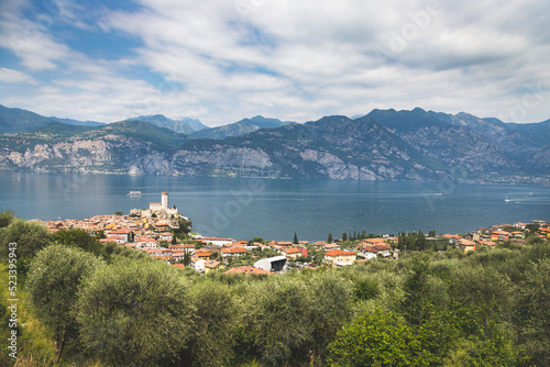 Idyllic coastline and nature in Italy: Blue water and a cute village at lago di garda, Malcesine,