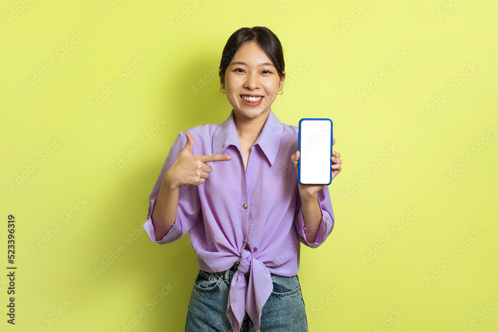 Happy Korean Woman Showing Phone Blank Screen Over Yellow Background Happy Korean Woman Showing Phone Blank Screen Over Yellow Background