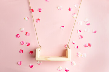 background texture empty space for baby. children's swing for a photo shoot of newborns. photo props. the bed is decorated with flowers. furniture for dolls and flying rose petals