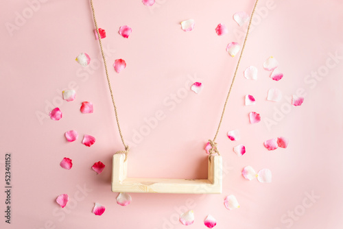 background texture empty space for baby. children's swing for a photo shoot of newborns. photo props. the bed is decorated with flowers. furniture for dolls and flying rose petals