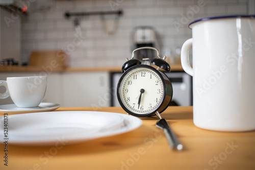 intermittent fasting concept alarm clock on kitchen table