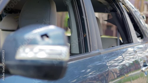 Close up broken left side rear view mirror of a car in blue. Auto insurance concept. Broken side window of the car on the driver's side as a result of an accident. Criminal incident.