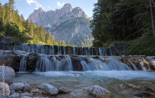 cascade on the river Pišnica with the Julian Alps in the backgro